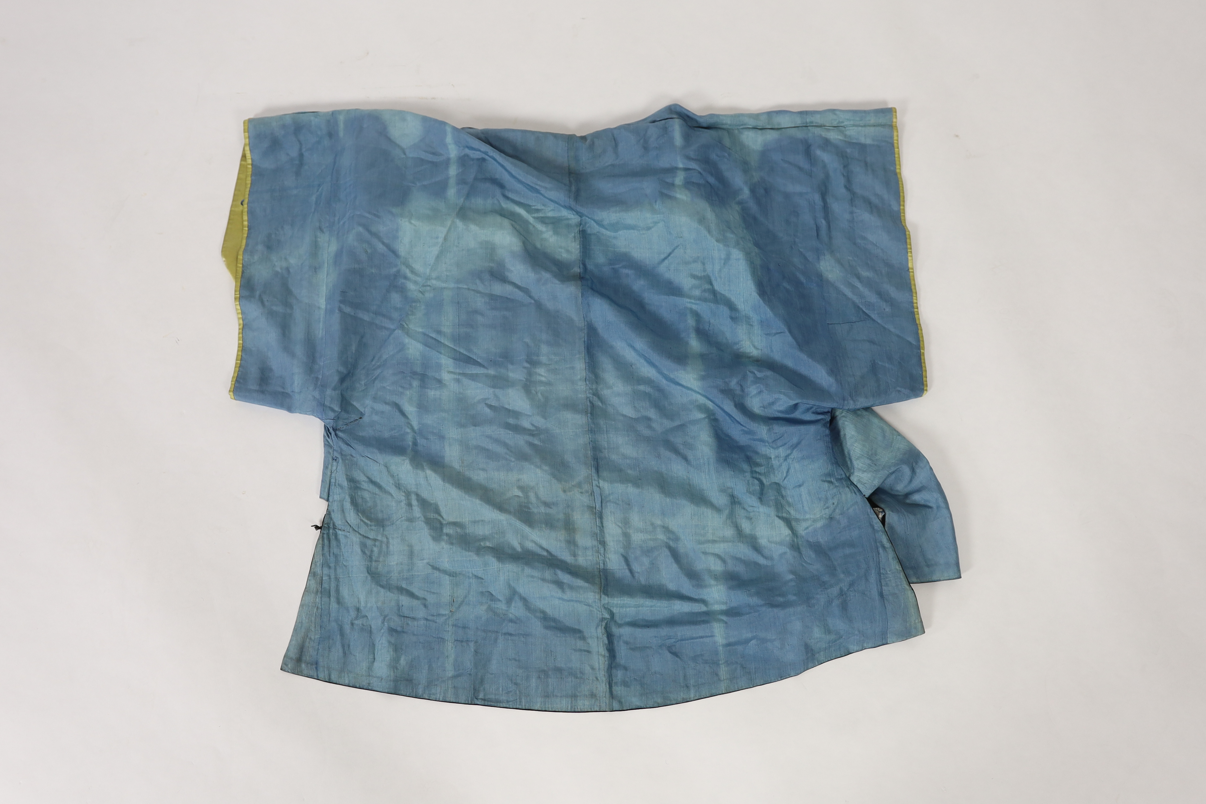 A late 19th / early 20th century silk damask robe, edged with highly ornate embroidered silk braiding, edged with fine gold and black borders, with yellow silk embroidered sleeve bands, the blue silk lining is faded in p